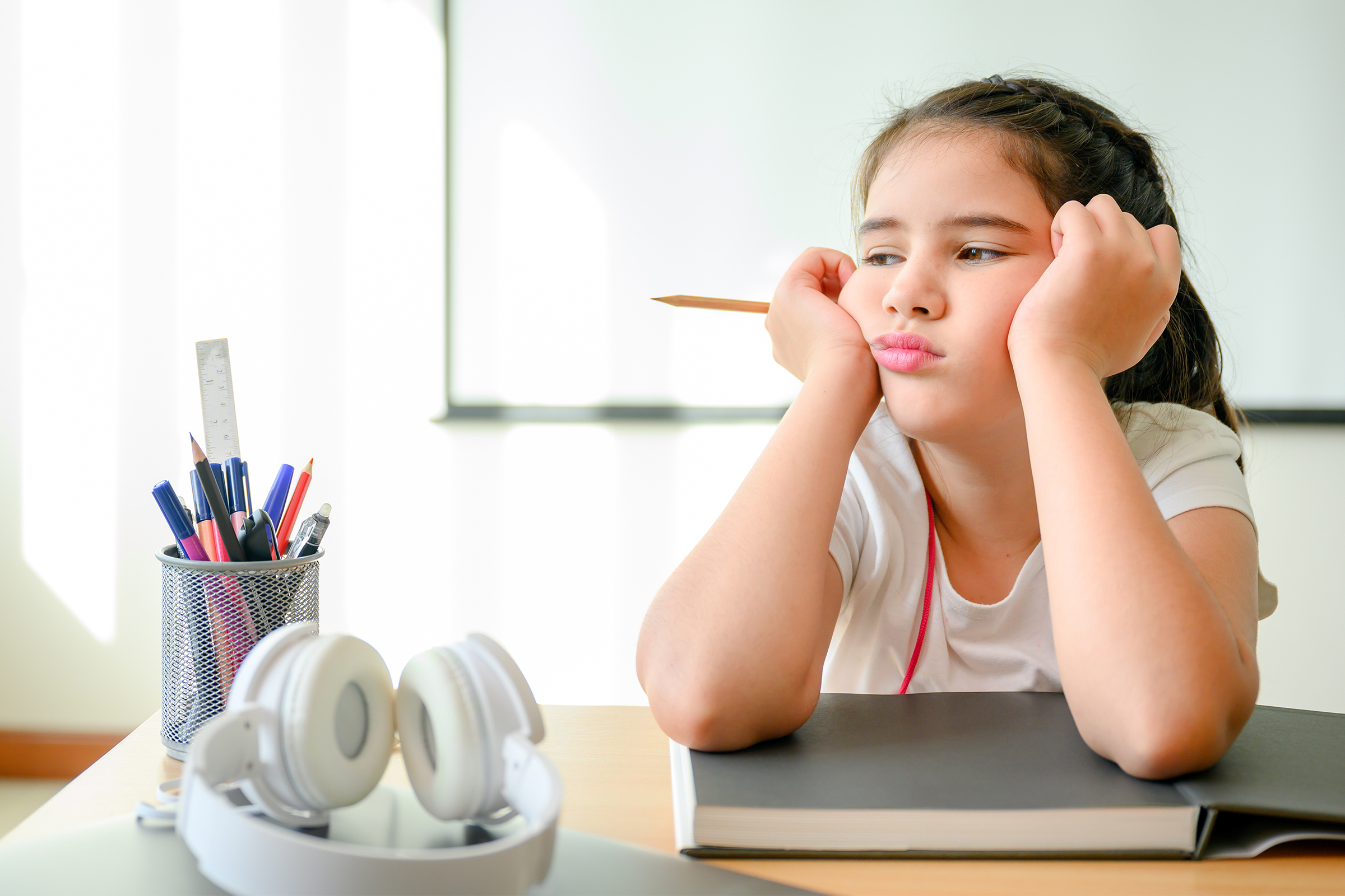Girl looking bored while studying at home