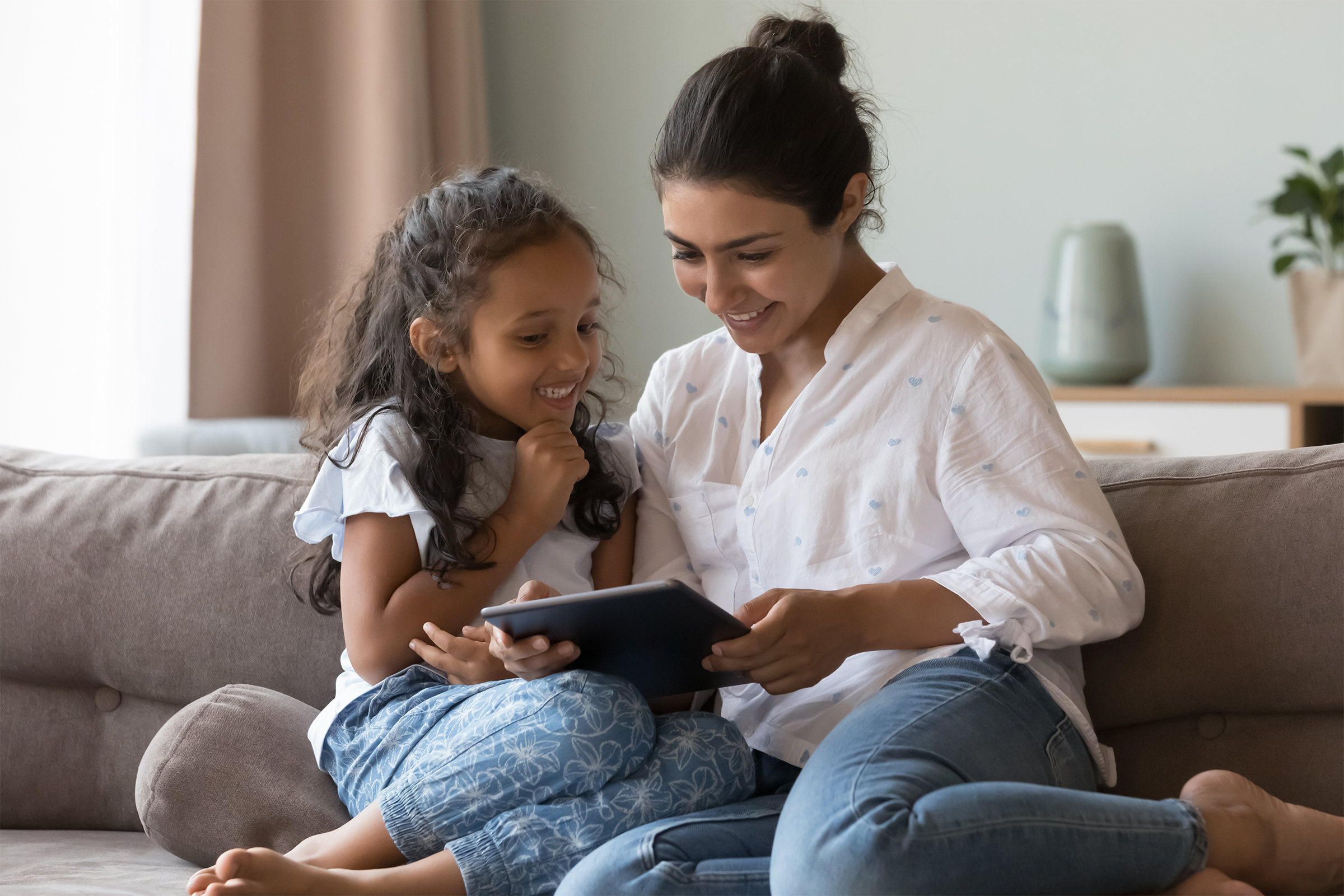 Mother and daughter using a tablet together at home
